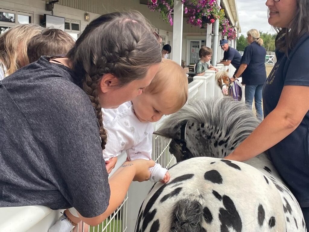 A mother and baby meeting a pony at the Keysoe Café